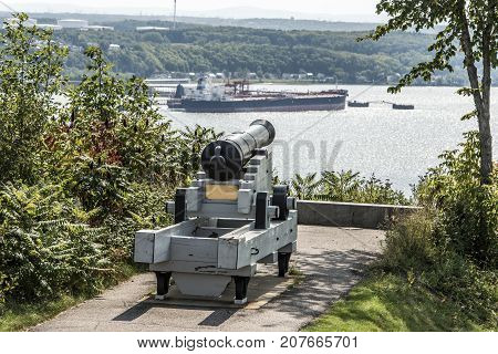 Cannon in Quebec City Canada - plaines Abraham overlooking Saint Lawrence river and Jean-Gaulin Refinery in Levis town