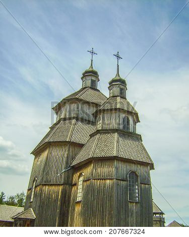 A Church Made Of Wood Stands Against The Blue Sky.