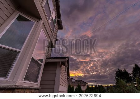Reflection of sunset sky on windows of suburban neighborhood home in North America