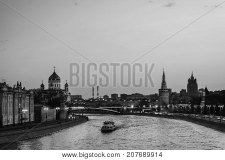 Moscow Russia. Aerial view of popular landmark Kremlin in Moscow Russia at night. Moscow Russia. Cars at the road. Illuminated Kremlin wall and touristic boat at Moscow river. Black and white