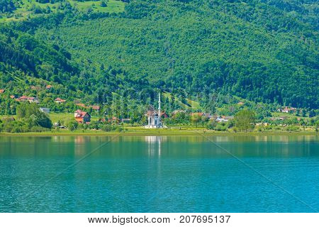 The White Mosque Is Located On The Shore Of A Mountain Lake.
