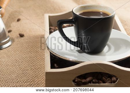Coffee grains and cup of coffee in wooden box. Coffee cup. Strong coffee. Coffee break
