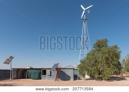 UPINGTON SOUTH AFRICA - JULY 6 2017: A wind and solar power installation on a farm in the Kalahari Region of the Northern Cape Province of South Africa