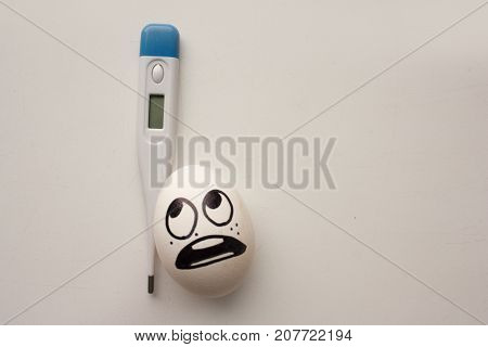 Flu Concept. A Funny Egg With A Face Holds