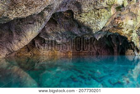 Beautiful blue underground waters contrasting with orange rock formations The Three Eyes National Park Dominican Republic.