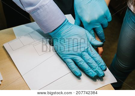 The investigator takes fingerprints from the suspect in the crime. Investigation is a crime.