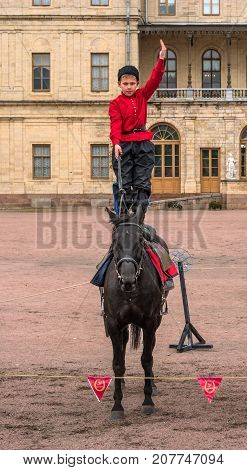 Gatchina St. Petersburg Russia - September 30 2017: Horse show of Cossacks on the parade ground of the Gatchina Palace. A Cossack boy stands on a horse.