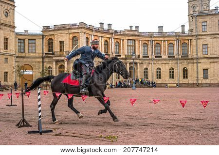 Gatchina St. Petersburg Russia - September 30 2017: Horse show of Cossacks on the parade ground of the Gatchina Palace. The Cossack rides with a sword.
