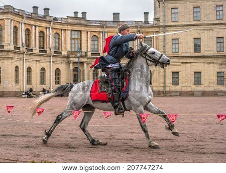 Gatchina St. Petersburg Russia - September 30 2017: Horse show of Cossacks on the parade ground of the Gatchina Palace. The Cossack rides with a sword.