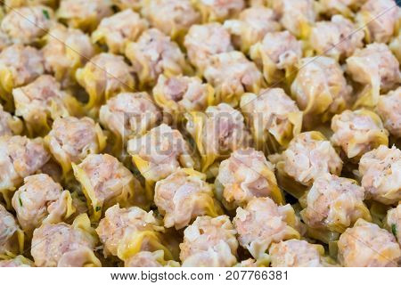 Focus on the front rows of Chinese steamed shrimp dumplings.