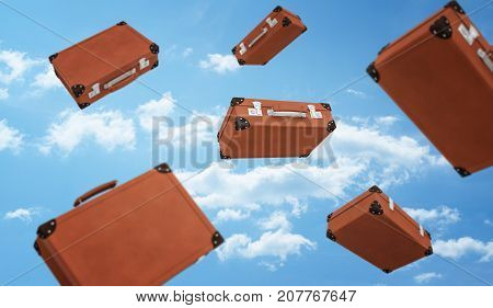 3d rendering of a several brown retro suitcases closed with buckles flying on cloudy sky background. Travelling and adventures. Luggage and bags. Necessities at hand.
