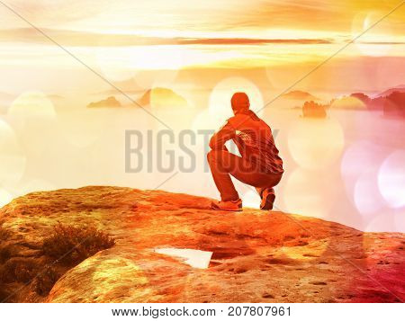 Tourist Sit On Peak Of Sandstone Rock And Watching Into Colorful Mist And Fog In  Morning Valley. Sa