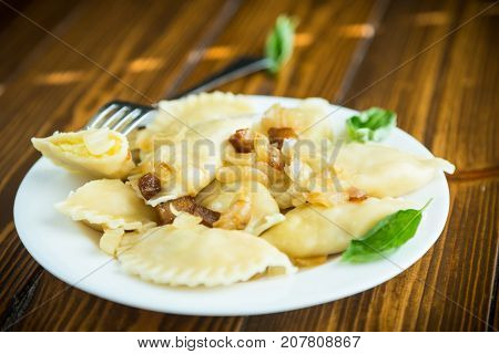 boiled dumplings with potatoes and fried onions on a plate