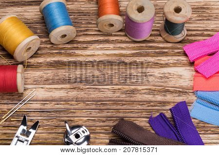 on a wooden surface a large set of spools of threads like a background