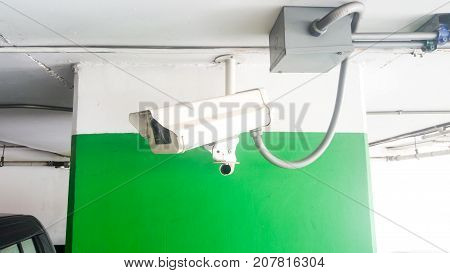 Security equipment concept. Closeup CCTV camera monitoring in the cars park. CCTV camera surveillance on car parking Safety system area control with copy space.