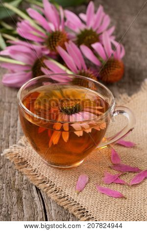 Cup of echinacea tea on old wooden table.