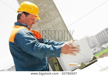 pedreiro de trabalhador de pedreiro de construção de levantamento e instalação de tijolo de silicato de cálcio