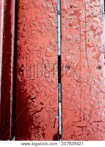 Old red wooden planks weathered from a bench