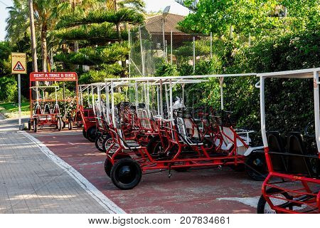 Parked rental tourist trike vehicles on one of the streets in Alcudia Mallorca