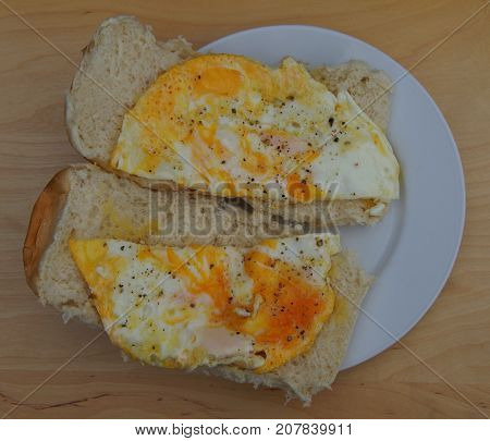 Simpel breakfast: Sandwiches with eggs, peper and salt on a white plate.