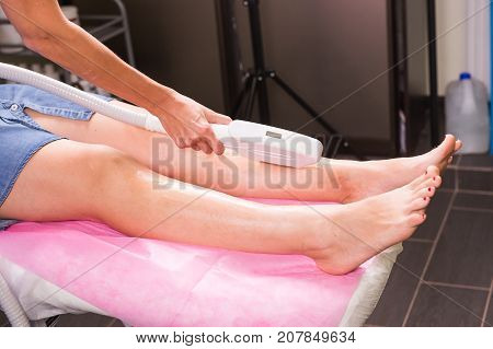 Hair removal cosmetology procedure from a therapist at cosmetic beauty spa clinic. Laser epilation and cosmetology