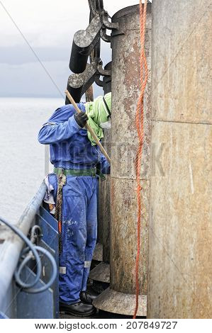 sailor paint old rusty pipe on top a funnel in a ship