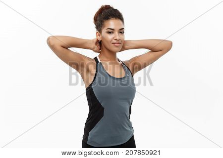 Healthy and Fitness concept - portrait of African American girl posing with fitness clothes over white studio background.