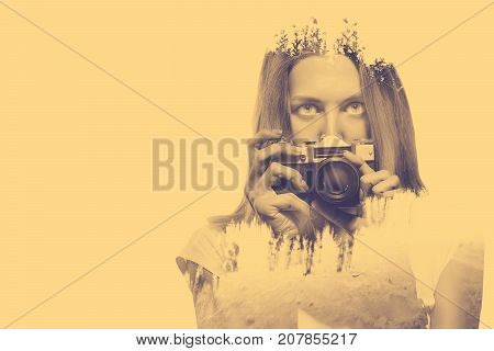 Double exposure of young woman holding old camera and nature background Toned