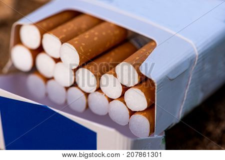 cigarette, cigarette on a wooden background, a pack of cigarettes, a close-up of a cigarette