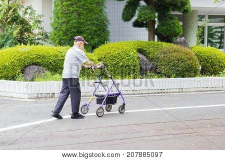 TOKYO JAPAN - SEPTEMBER 16 : unidentified asian old leprosy man walking with wheel waker for exercising in Tama Zensho Hospital on September 16 2017 in Tokyo Japan.