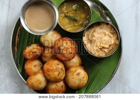Kuzhi Paniyaram served with coconut chutney and sambar- South Indian breakfast with black lentils and rice