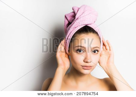 girl after shower with a pink towel on her head looking at the camera, isolated