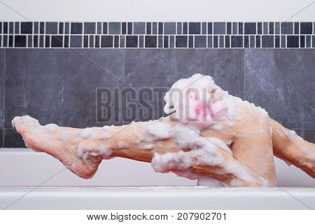 Close Up Of Woman Washing Leg With Sponge In Bathtub