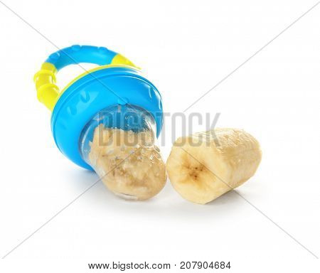 Baby's nibbler and banana on white background