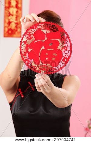 Young woman holding paper cutting face hidden