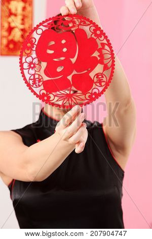 Young woman holding paper cutting face hidden
