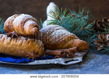 Christmas and New Year 2017 background with continental breakfast - cinnamon fresh orange and croissant. Decorations - snowflake crochet napkin pine cones.