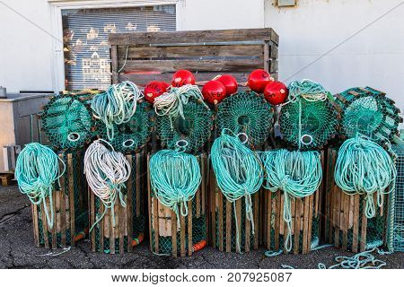 Lobster traps standing on a pier prepared for fishing with ropes and buoys in a Norwegian fishing village