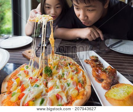 Brethren eat a pizza togather in restaurant food family and child concept