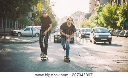Two Pro Skateboard Rider Ride Skate Through Cars On Street