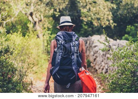 Woman Hiking On Country Footpath With Rock Fence And Woods.