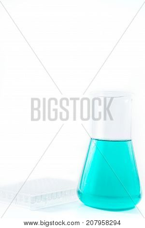 research, science and clinic background. 96 well micro plate and  laboratory beakers with colorful liquids and reagents.
