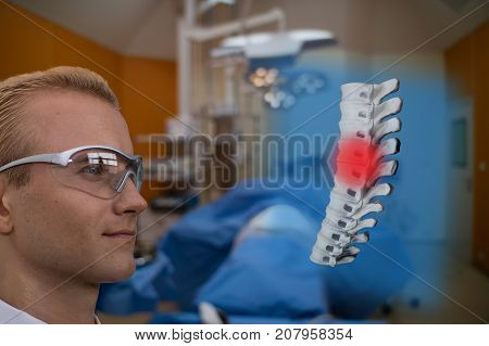 smart medical technology concept doctor use glasses to use augmented reality to show the injury of spine bone of the patient for analysis and find the way to treatment in surgery room at hospital