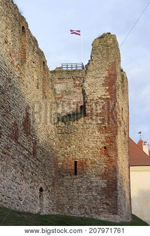 The ruins of the Livonia Order Castle was built in the middle of the 15th century. Bauska Latvia in autumn. Latvian flag on the top of the tower