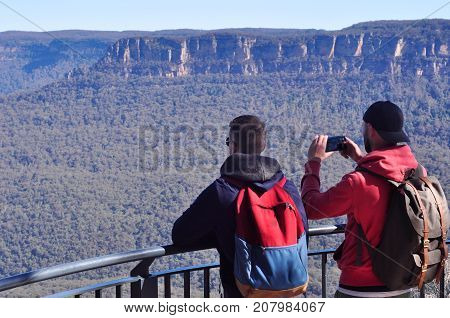 young mens taking photo and enjoying scenic view of blue mountains near Sydney New South Wales Australia