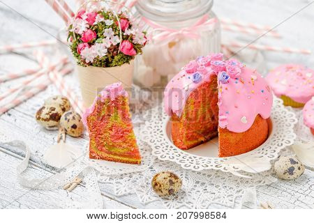 Traditional Easter cake with decorations and cupcakes on wooden table