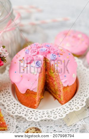 Traditional Easter cake with decorations and cupcakes on wooden table