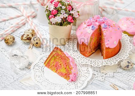 Traditional Easter cake with decorations and cupcakes on wooden table