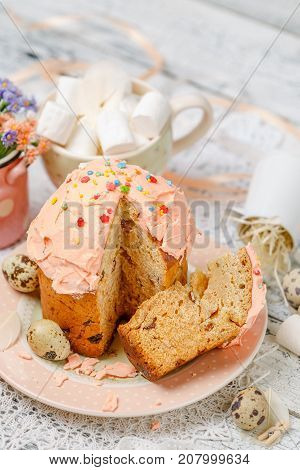 Traditional Easter cake with decorations and cupcakes on wooden table