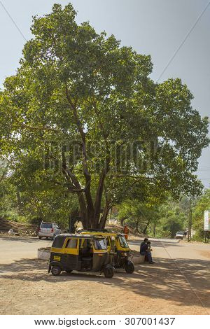 Tivim,goa,india - 20.12.2018 Two Indian Black And Yellow Moto Rickshaws Taxi Are Parked In The Shade
